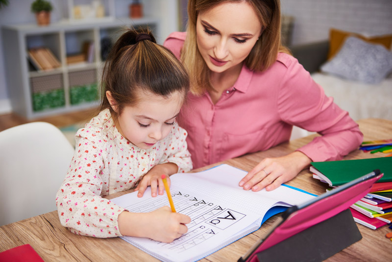 young-woman-helping-girl-with-homework-8BSC5RF.jpg